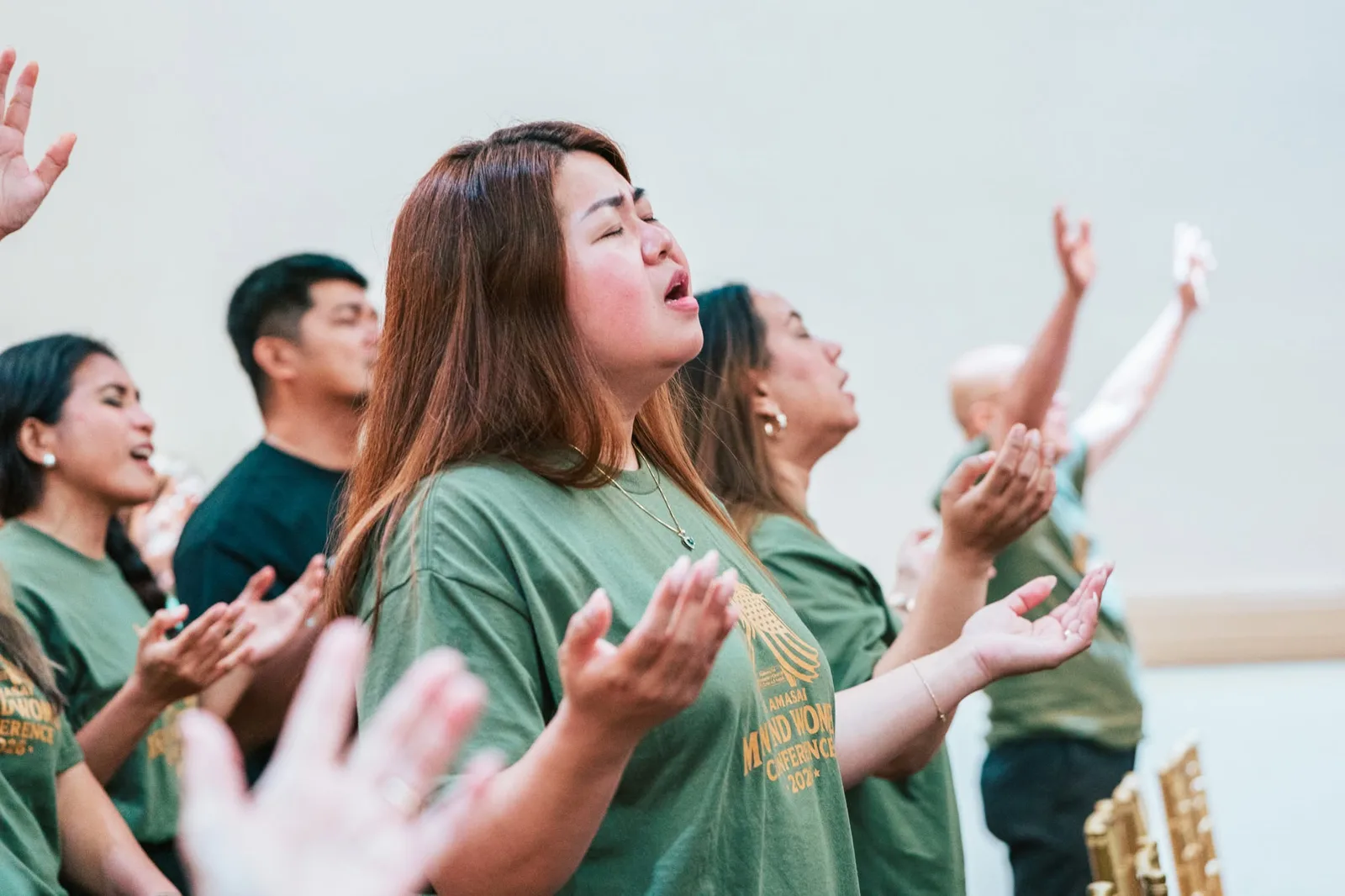 The congregation singing with hands lifted during Sunday worship